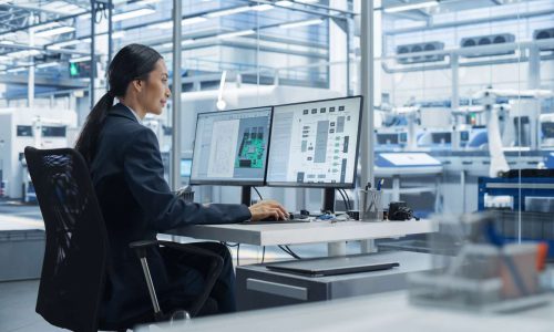Asian Industrial Engineer Doing Creative Work on Computer in Off